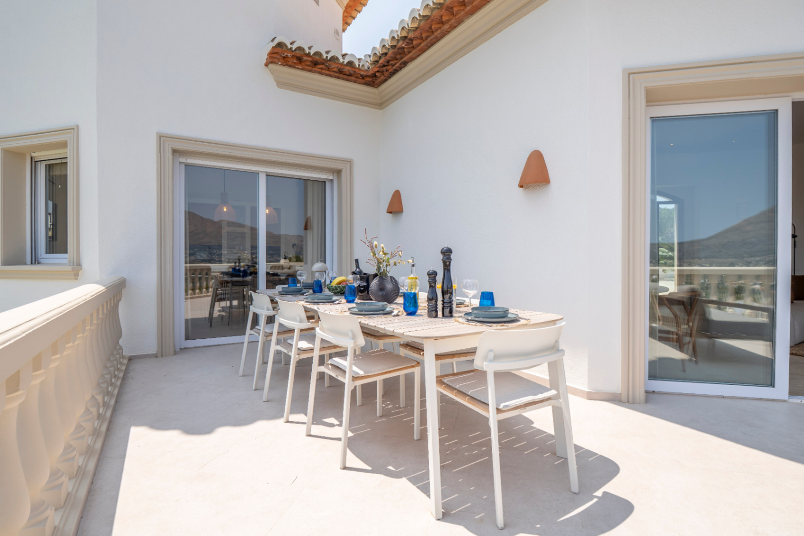 Terrasse mit Essbereich im Freien, hellem Holztisch und Panoramablick in Jávea.