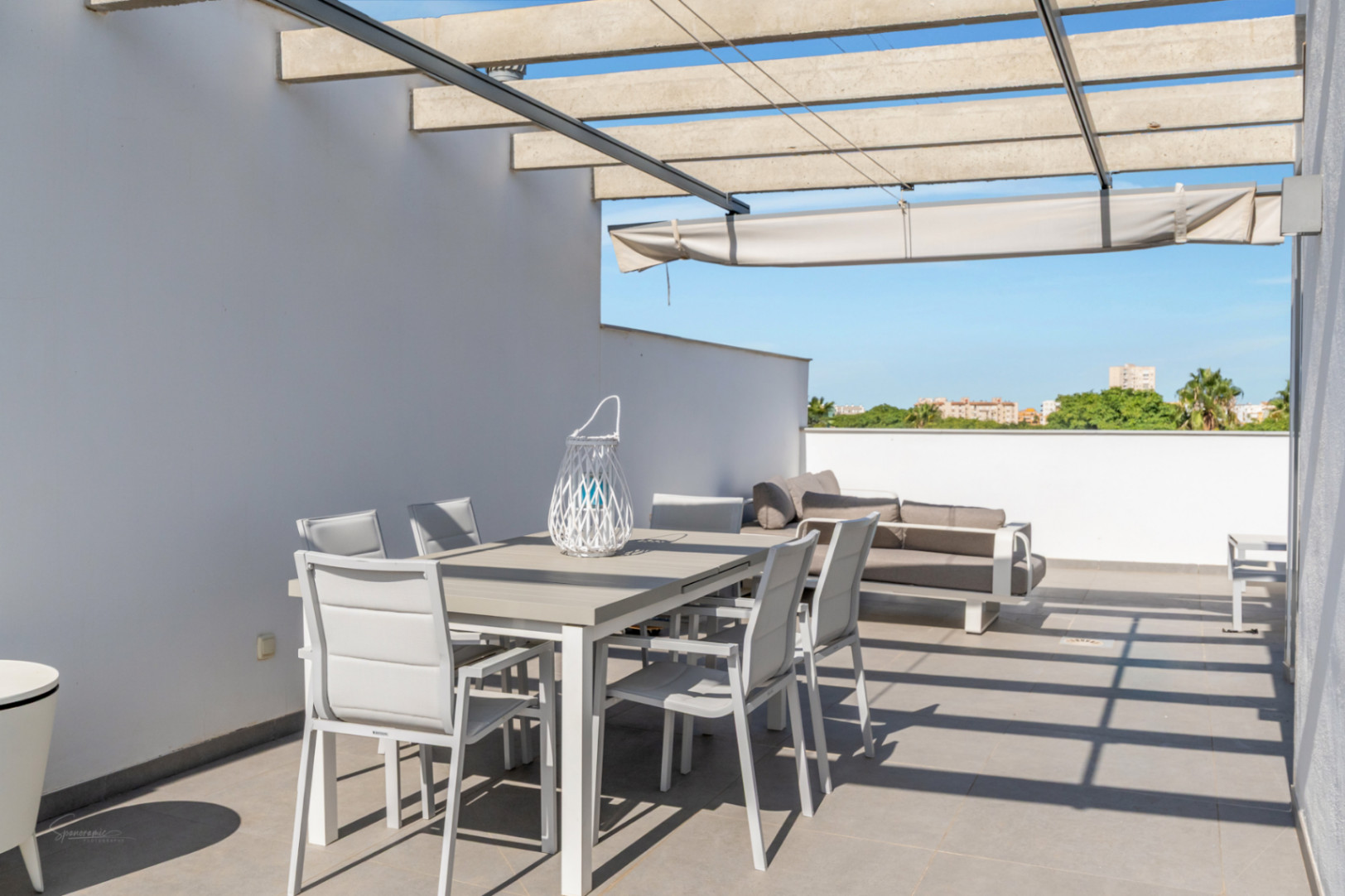 Private Dachterrasse mit Betonpergola, ausziehbarer Markise und Essbereich im Freien mit weitem Blick auf die Umgebung.