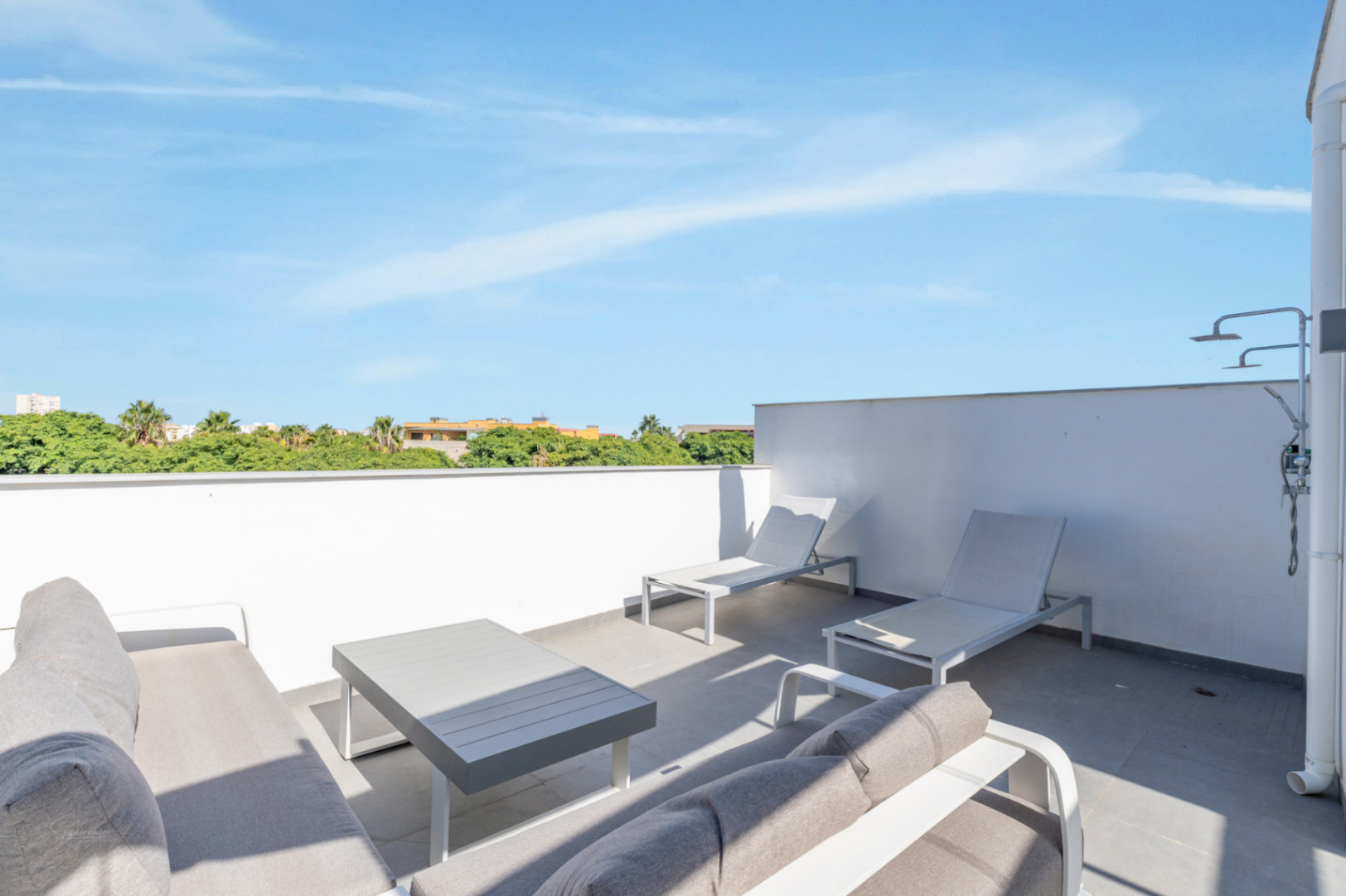 Private Dachterrasse mit Loungebereich, Sonnenliegen und Außendusche. Der Bereich bietet einen weiten Blick auf die umliegende Landschaft.