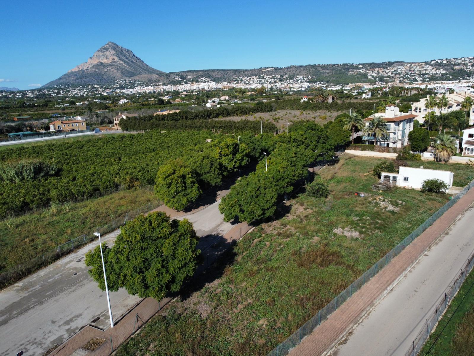 Luftaufnahme des Wohngrundstücks in Jávea mit befestigter Zufahrt, Baumbestand und dem markanten Berg Montgó im Hintergrund.