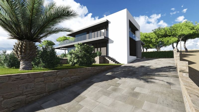 Außenansicht der modernen Villa mit gepflasterter Auffahrt, Natursteinmauern, weißer Fassade mit Glasbalkonen und mediterraner Gartenanlage.
