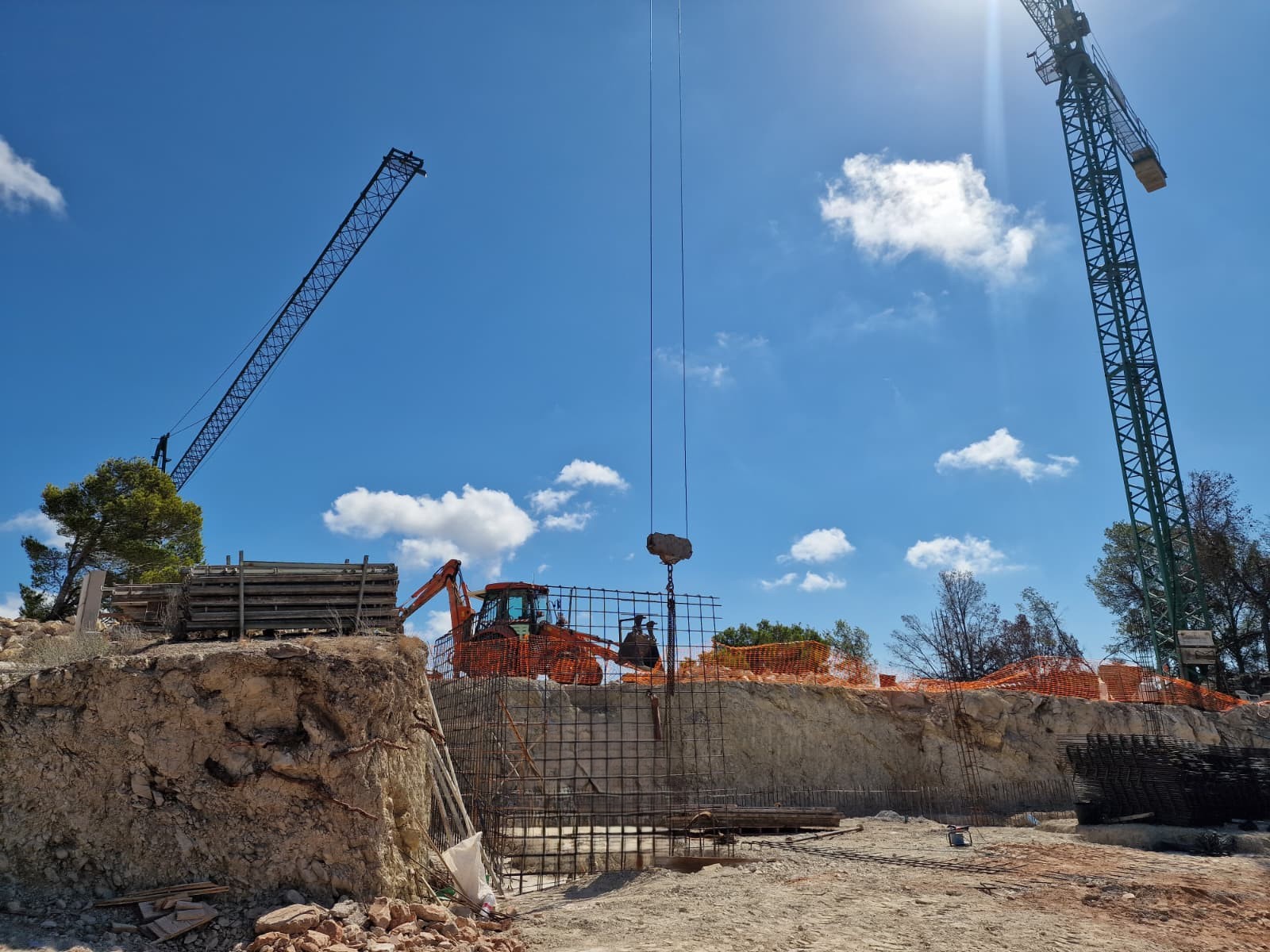 Baufortschritt in Moraira mit Erdarbeiten, Stahlbewehrung für das Fundament und dem Einsatz von Turmdrehkranen auf dem exklusiven Grundstück.