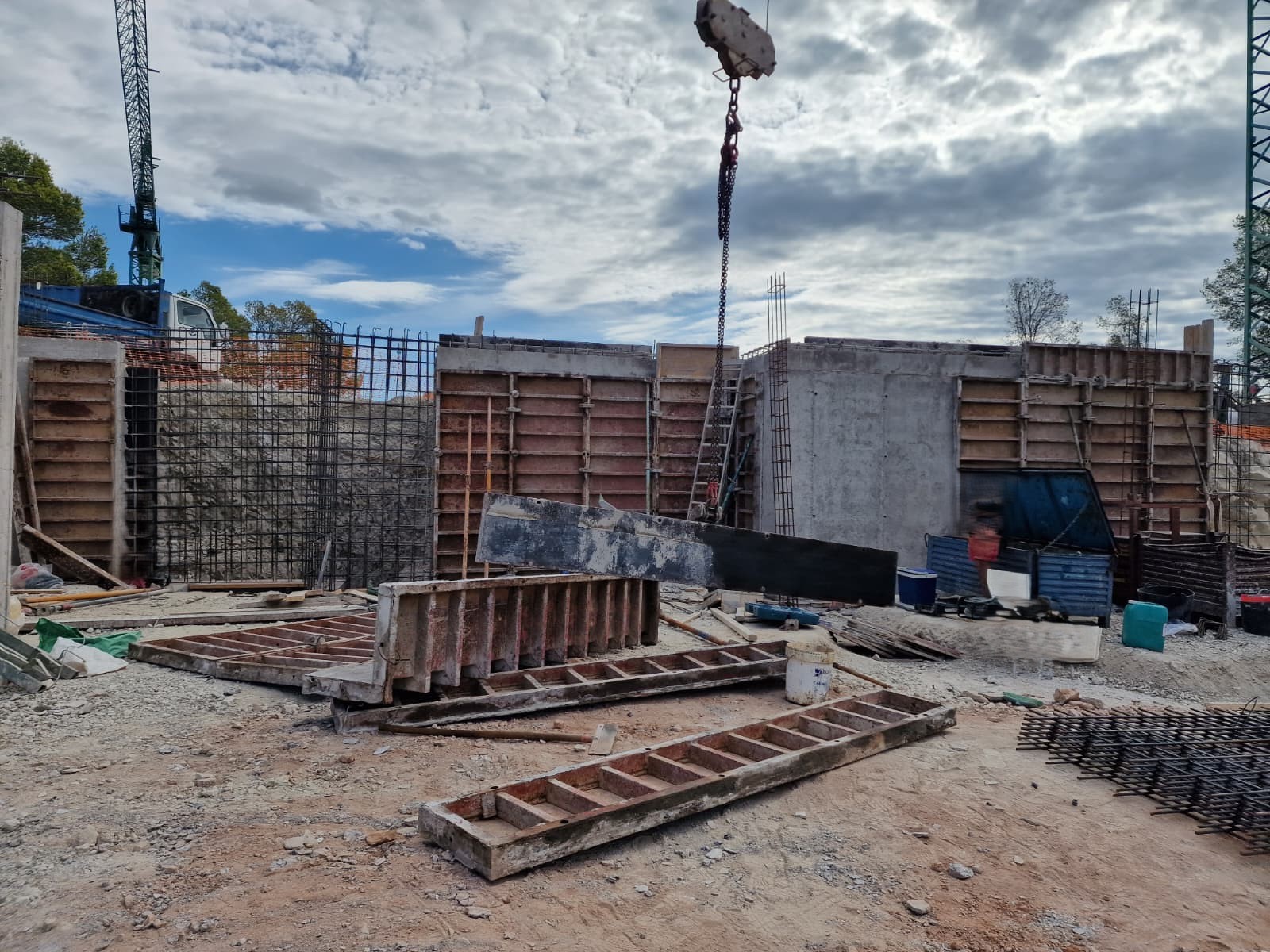 Fortschritt der Rohbauphase mit Stahlbetonwänden, Metallschalungen und Kranarbeiten auf der Baustelle der Villa in Moraira.