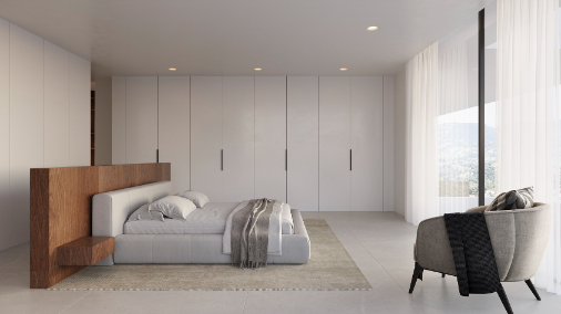 Hauptschlafzimmer mit hölzernem Raumteiler-Kopfteil, raumhohen Einbauschränken und großen Fenstern mit Blick auf die umliegenden Berge.