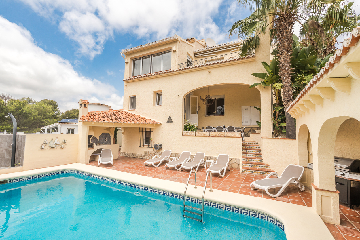 Außenansicht des 8x4m Pools und der Terrakotta-Terrasse mit überdachtem Grillbereich, Sonnenliegen und einer bogenförmigen Naya für Mahlzeiten im Freien.