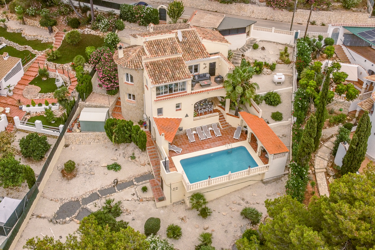 Luftaufnahme der Villa mit 8x4m Pool, Terrakotta-Terrassen und Natursteinturm, umgeben von einem pflegeleicht angelegten mediterranen Garten.