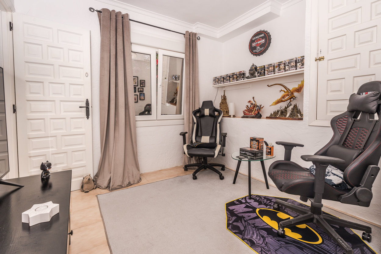 Vielseitiges Hobbyzimmer mit Gaming-Stühlen, Sammlerregalen und hellen Fliesenböden. Ausgestattet mit doppelt verglasten Fenstern und weißen Kassettentüren.