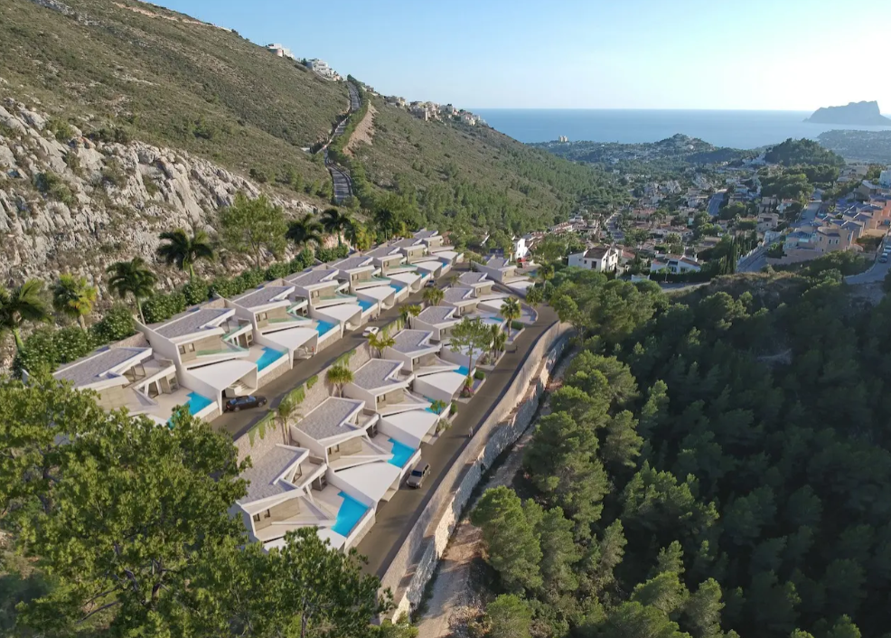 Luftbild von sechzehn modernen Terrassenvillen in Benitachell, jeweils mit privatem Pool und Panoramablick auf die Mittelmeerküste und den Peñón de Ifach.