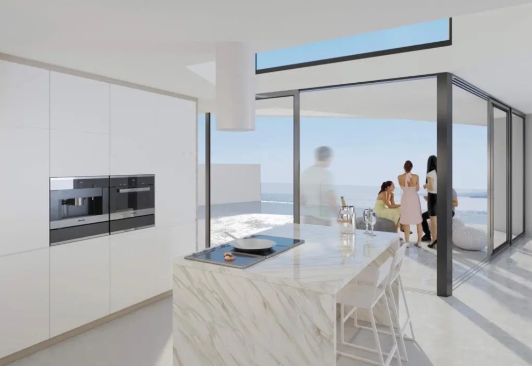 Moderne Küche mit Marmor-Insel, integriertem Kochfeld und bodentiefen Glasfronten, die einen direkten Zugang zur Terrasse mit Meerblick ermöglichen.