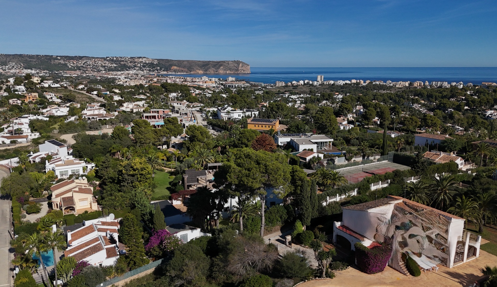 Panorama-Luftaufnahme des Wohngebiets Pinosol in Jávea mit weitem Blick über die Küste bis hin zum markanten Kap San Antonio am Mittelmeer.