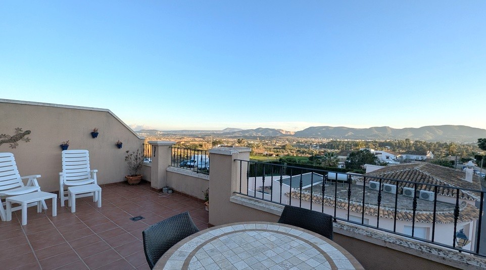 Großzügige Dachterrasse mit Terrakotta-Fliesen, Essbereich im Freien und weitem Panoramablick auf die umliegende Landschaft und Bergkette.
