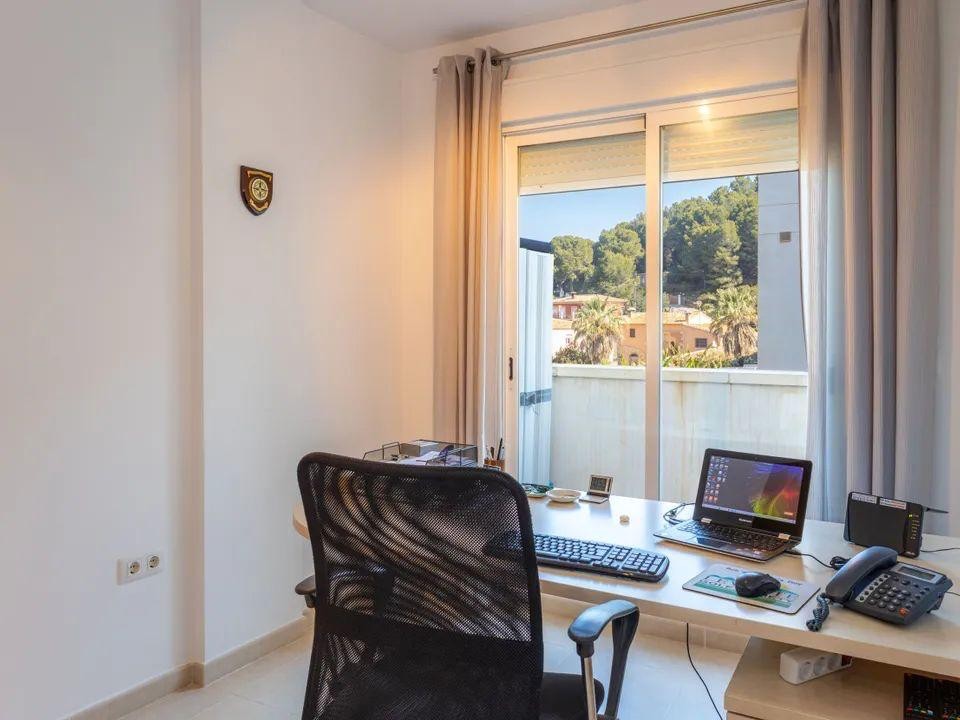 Helles Arbeitszimmer mit großem Schreibtisch und Schiebetüren, die einen weiten Blick auf die bewaldeten Hügel von Jesús Pobre bieten.