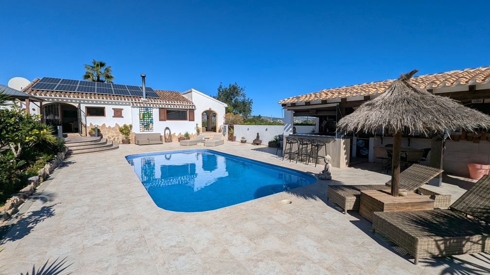 Außenbereich der Hauptvilla mit privatem Pool, Steinterrasse und ausgestatteter Sommerküche mit Bar sowie Solaranlage auf dem Dach der Finca.