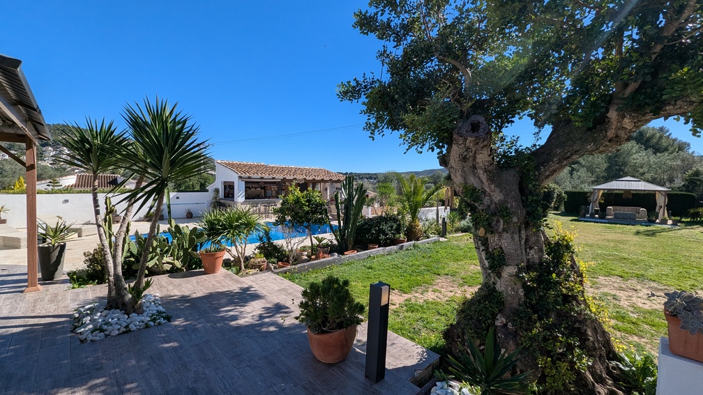 Mediterraner Garten mit privatem Pool, voll ausgestatteter Sommerküche und einem schattigen Pavillon auf einer gepflegten Rasenfläche.
