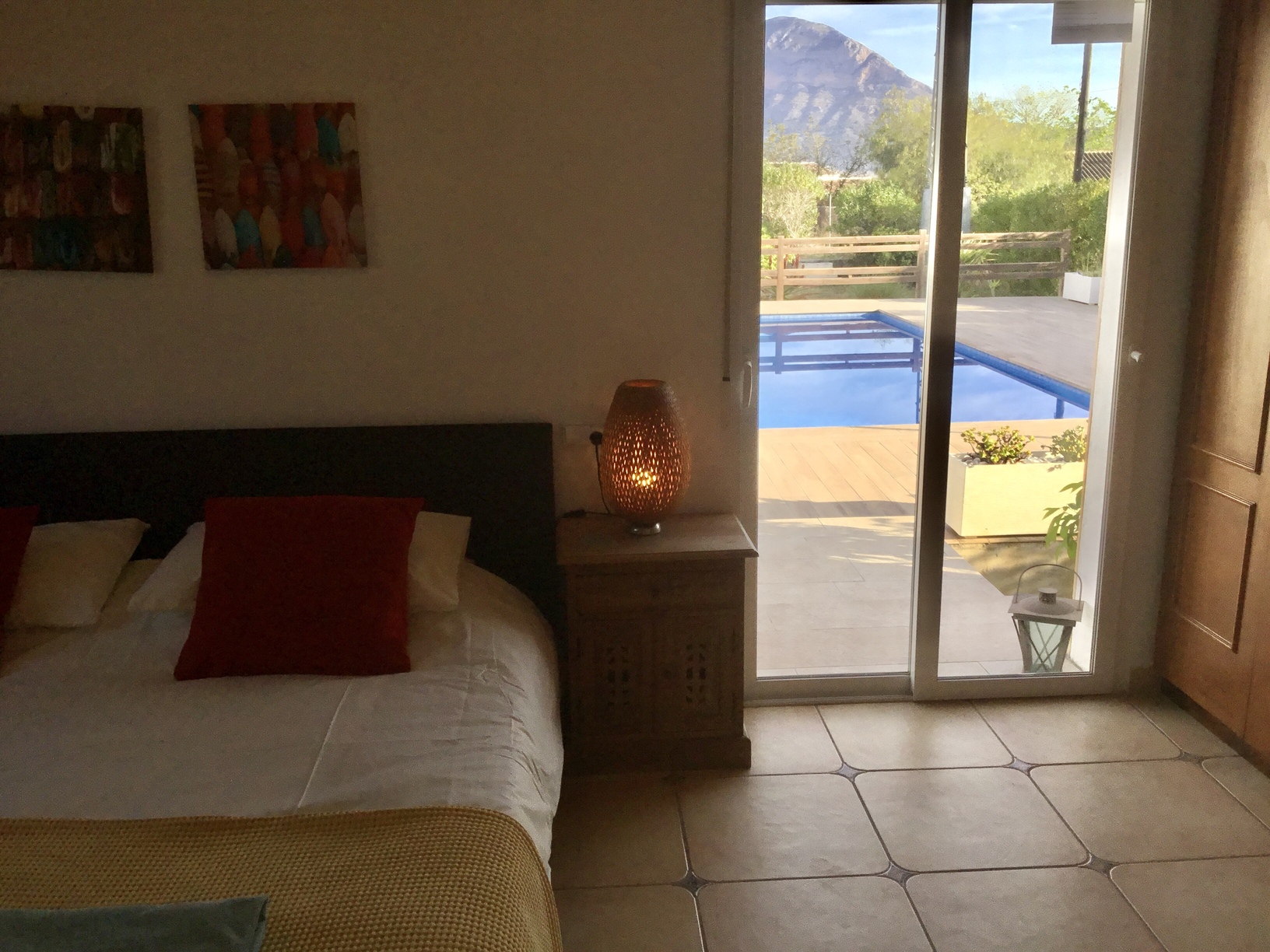 Schlafzimmer mit direktem Zugang zur Poolterrasse durch Glasschiebetüren, mit Blick auf den Berg Montgó und Fliesenboden.