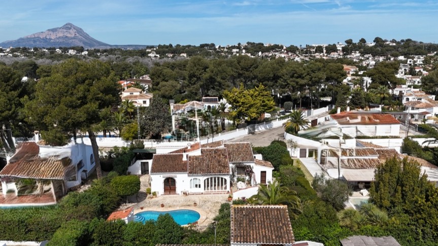 Luftaufnahme der traditionellen Villa mit privatem Pool, Terrakottadach und Garten, im Hintergrund der markante Berg Montgó.