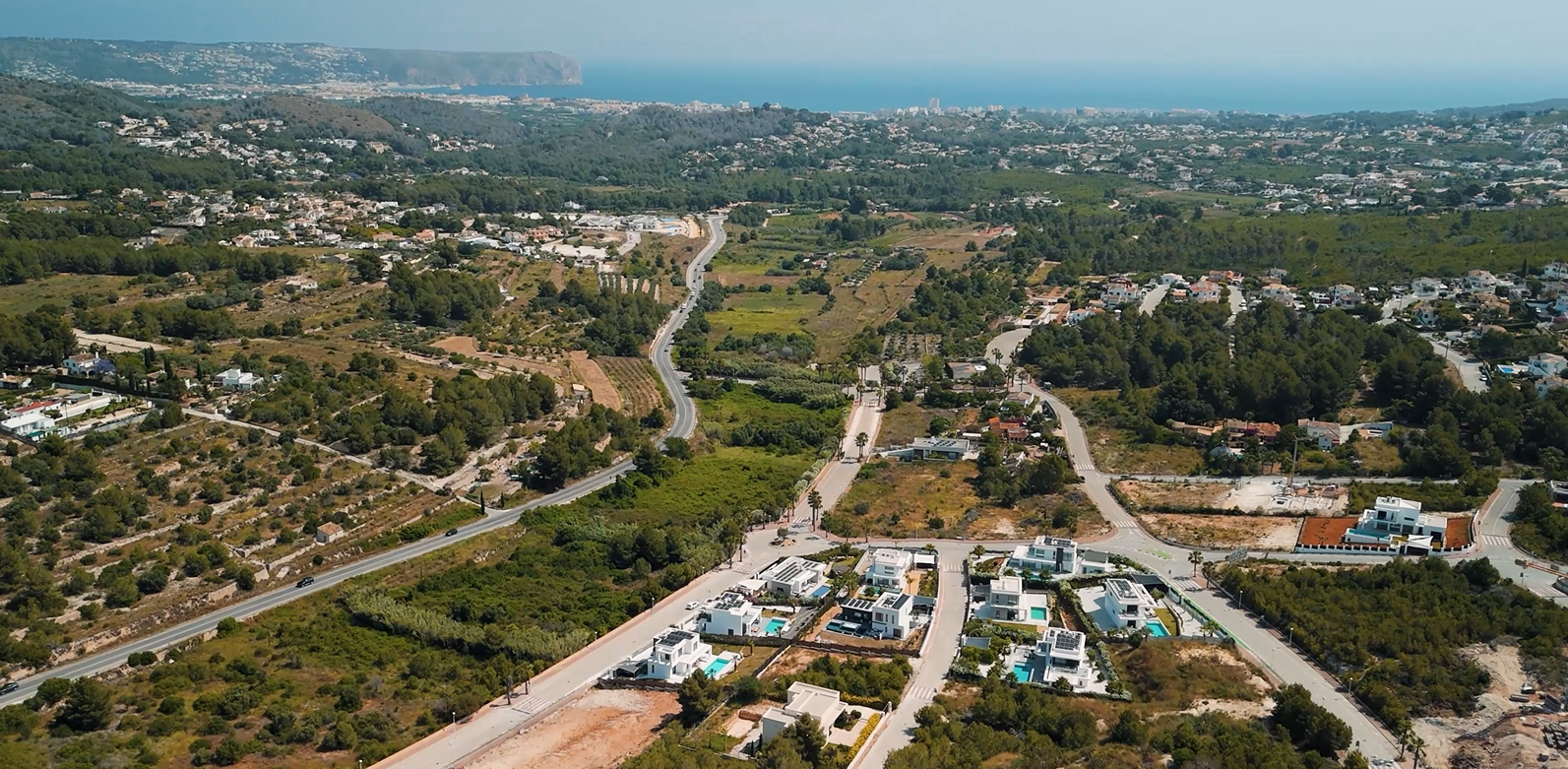 Luftaufnahme des Wohngebiets Villas del Vent in Jávea mit modernen Villen und Grundstücken sowie Panoramablick auf das Mittelmeer und die Küste.