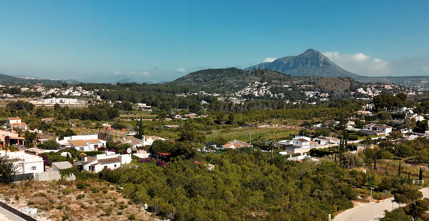 Erhöhte Aussicht auf die Urbanisation Lomas del Rey in Jávea mit dem markanten Berg Montgó im Hintergrund und mediterranen Villen inmitten von Pinien.