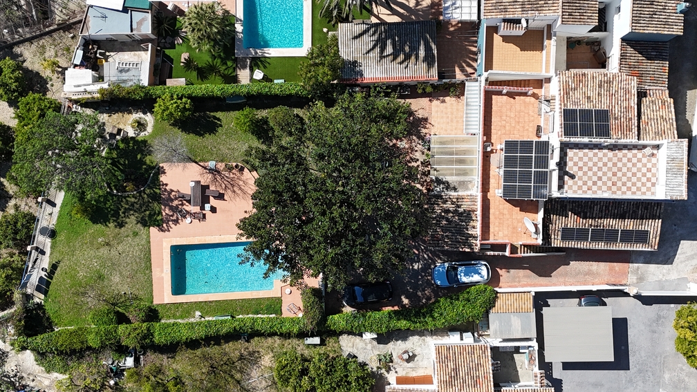 Luftaufnahme der Villa mit privatem Pool, Garten und Solaranlagen auf dem Ziegeldach, eingebettet in üppige mediterrane Vegetation.