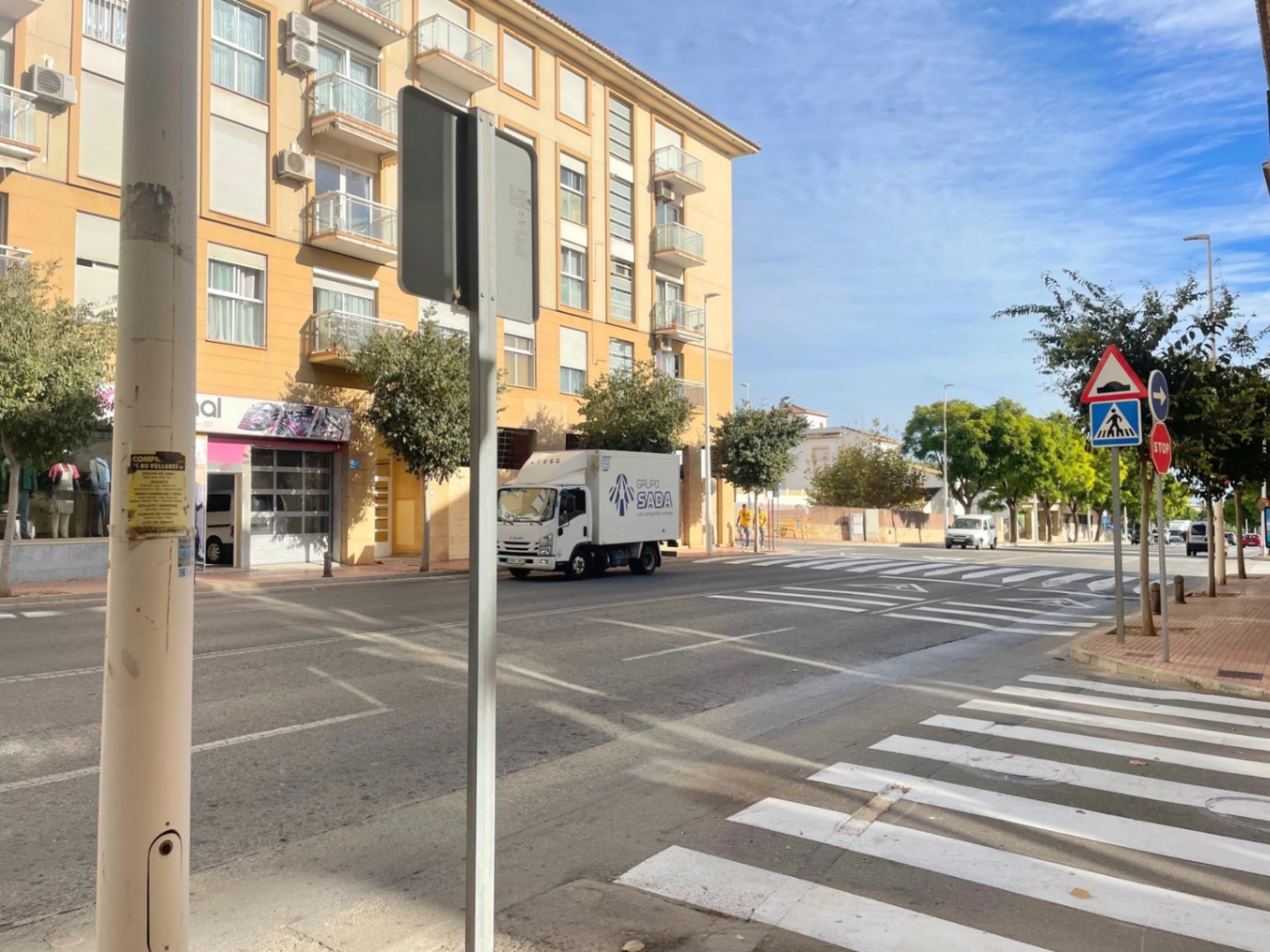 Außenansicht der Avenida Palmela in Jávea, die die hochfrequentierte städtische Lage und die gute Erreichbarkeit für Fußgänger vor dem Geschäftslokal zeigt.