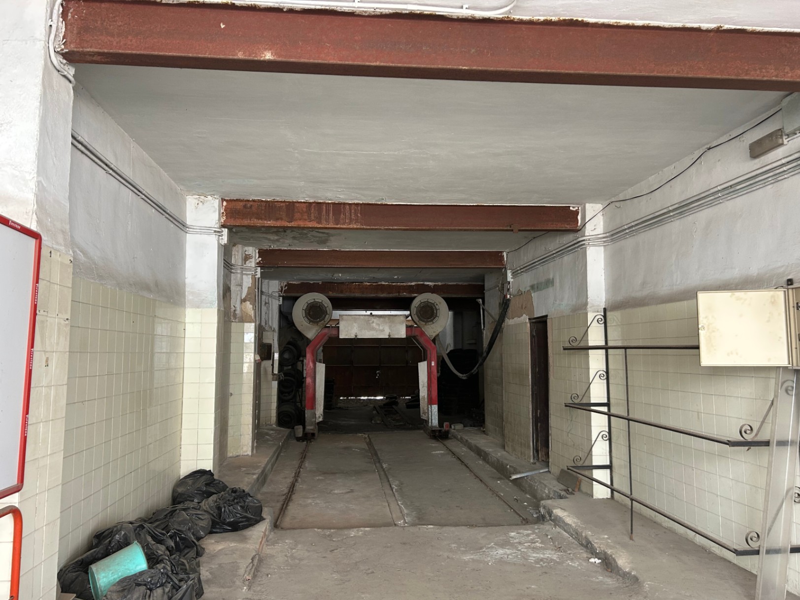 175 m² große Gewerbefläche im Erdgeschoss mit hohen Decken, sichtbaren Stahlträgern und Industrieschienen, perfekt für ein Loft- oder Garagenprojekt geeignet.