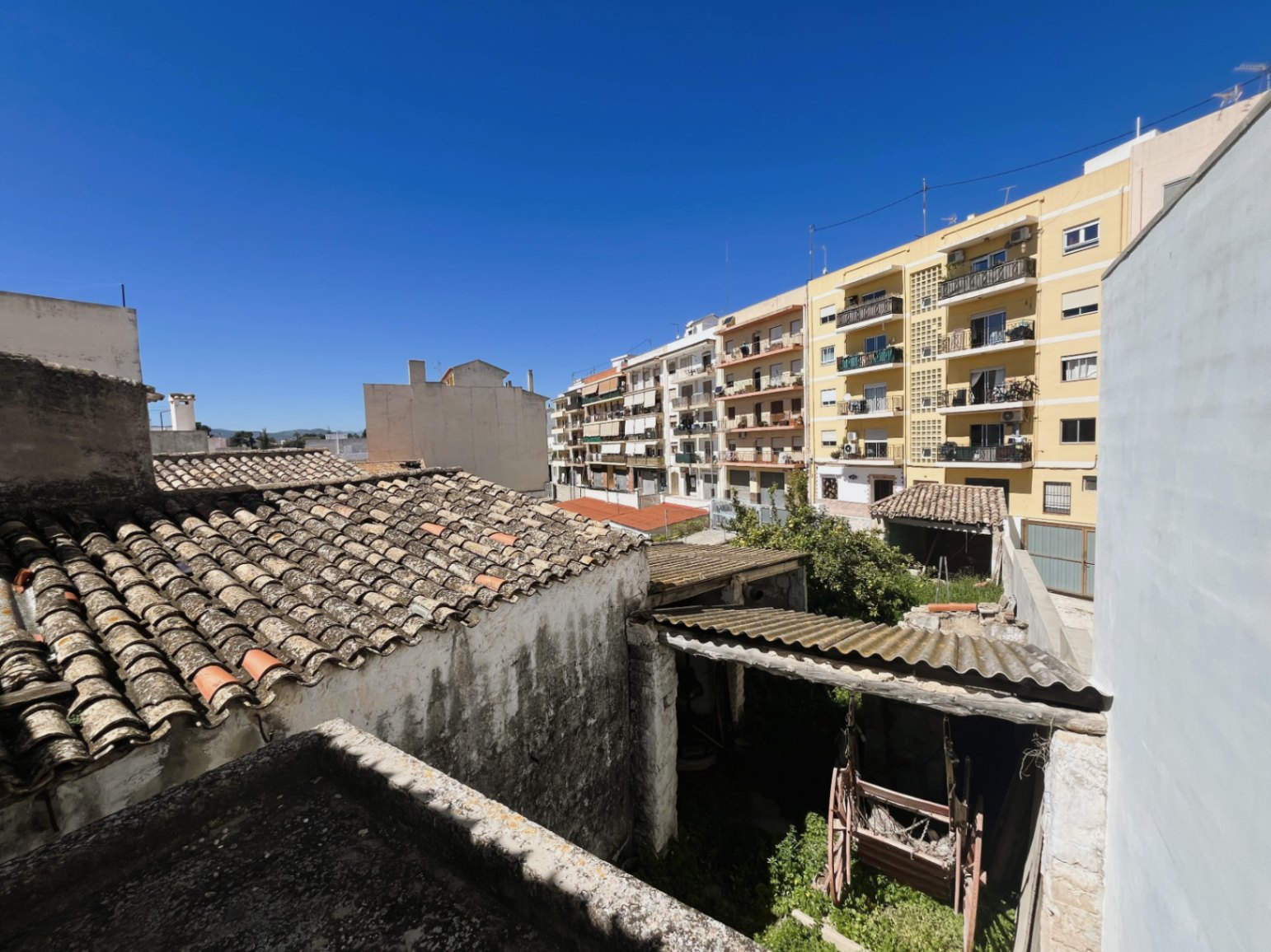Erhöhter Blick auf den Hinterhof und die traditionellen Ziegeldächer, der die Einbindung des Anwesens in das Stadtbild von Jávea verdeutlicht.