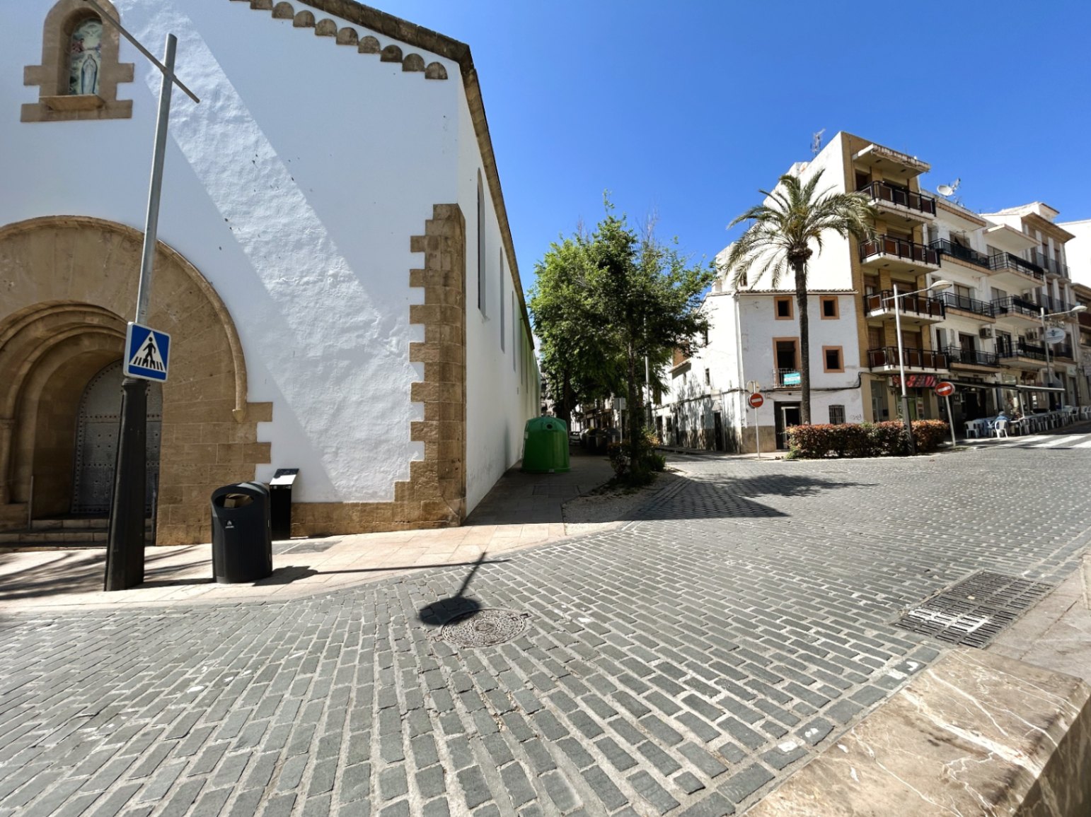 Außenansicht der kopfsteingepflasterten Straße neben einem historischen Gebäude mit traditionellen Tosca-Steinbögen in der Altstadt von Jávea.