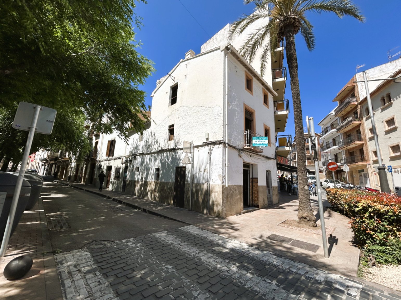 Außenansicht des dreistöckigen Eckhauses in der Altstadt von Jávea mit traditioneller weißer Fassade, Holzfensterläden und sonniger Ausrichtung.