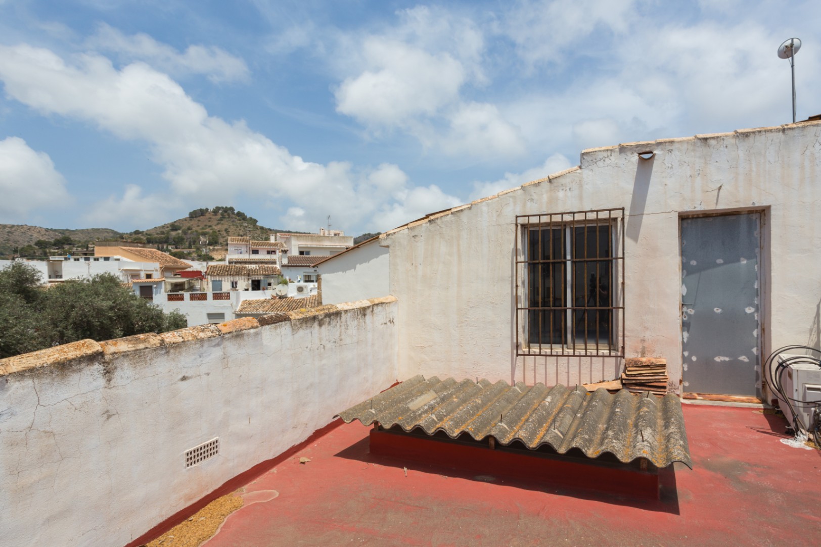 Dachterrasse mit rotem Bodenbelag und weitem Blick über die Stadt und die umliegenden Hügel von Jávea. Verfügt über einen direkten Zugang.
