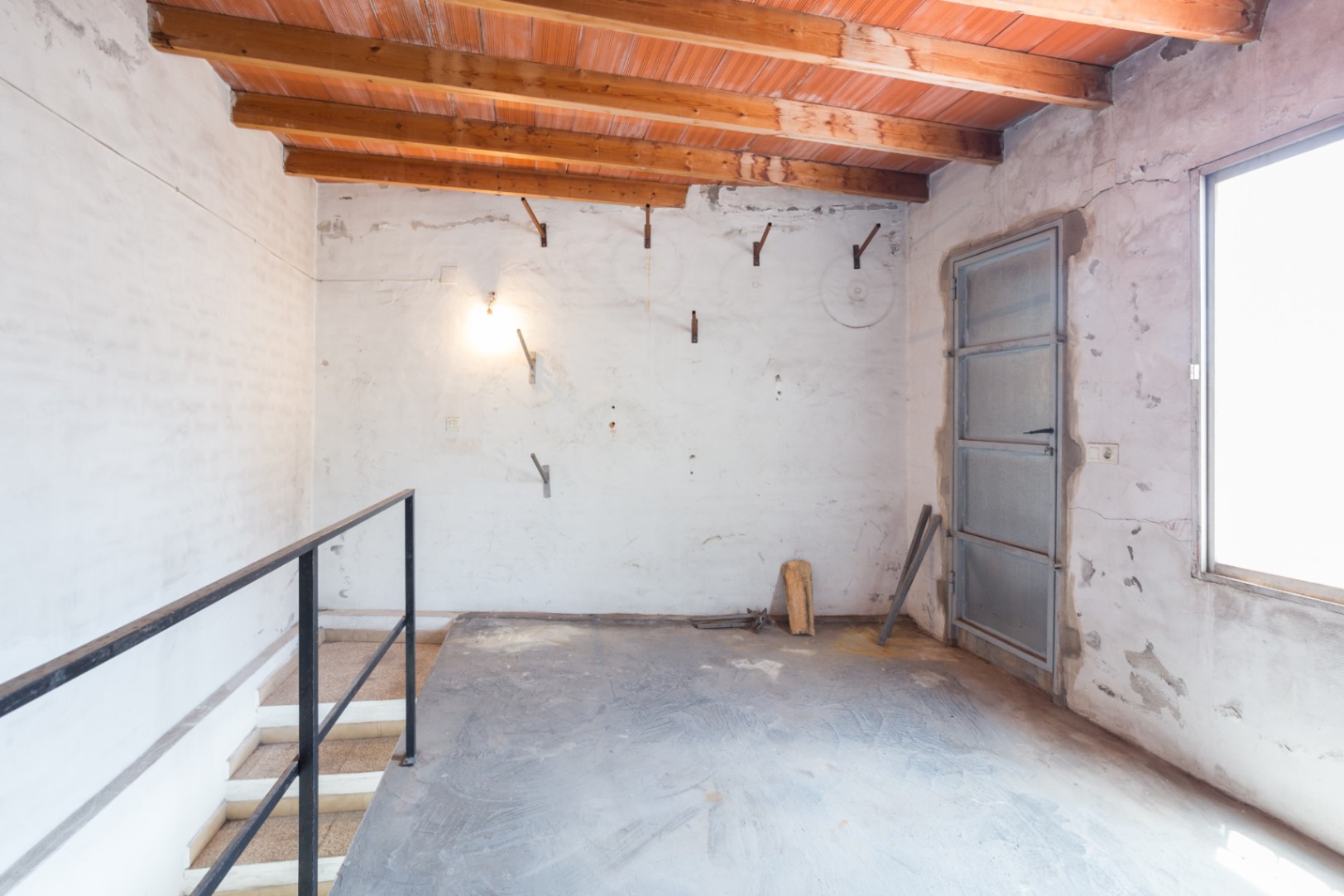 Obergeschoss mit Holzbalkendecke und Terrakotta-Elementen. Verfügt über einen Treppenaufgang mit Metallgeländer, Betonboden und industrielle Metalltüren und -fenster.