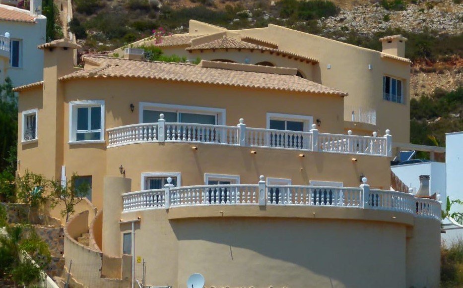 Außenansicht der Villa mit geschwungenen Balkonen und weißen Balustraden in Cumbre del Sol.