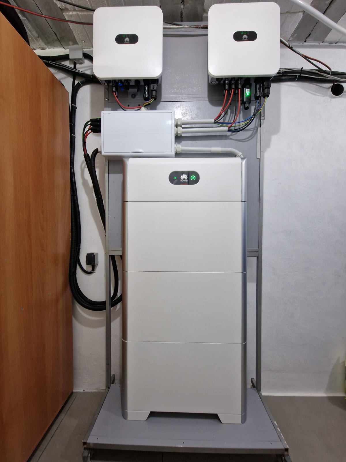 Installation von Huawei Solarreglern und Batterie in einem Technikraum. Sichtbare Verkabelung.