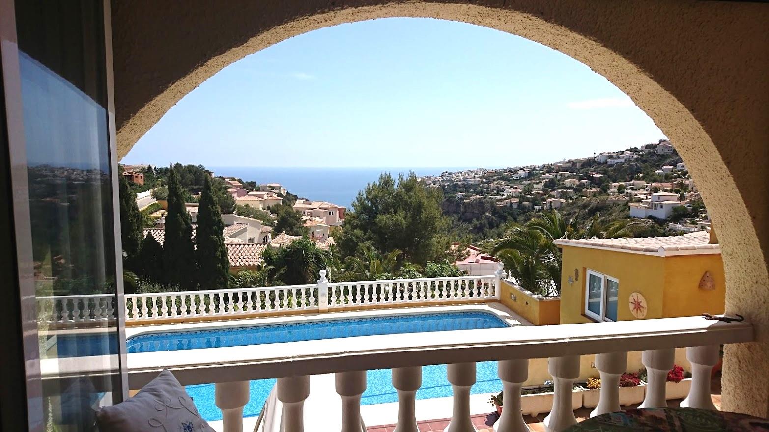 Blick von der bogenförmigen Naya auf den privaten Pool und das Mittelmeer, eingerahmt von weißen Balustraden und der Küstenlandschaft.