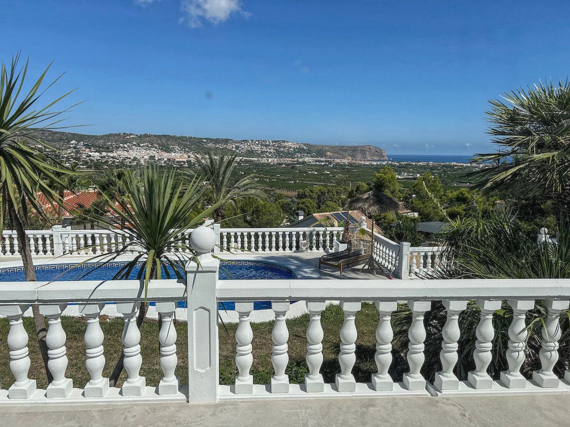 Erhöhte Terrasse mit klassischer weißer Balustrade, privatem Pool und Panoramablick über das Tal bis hin zum Mittelmeer.