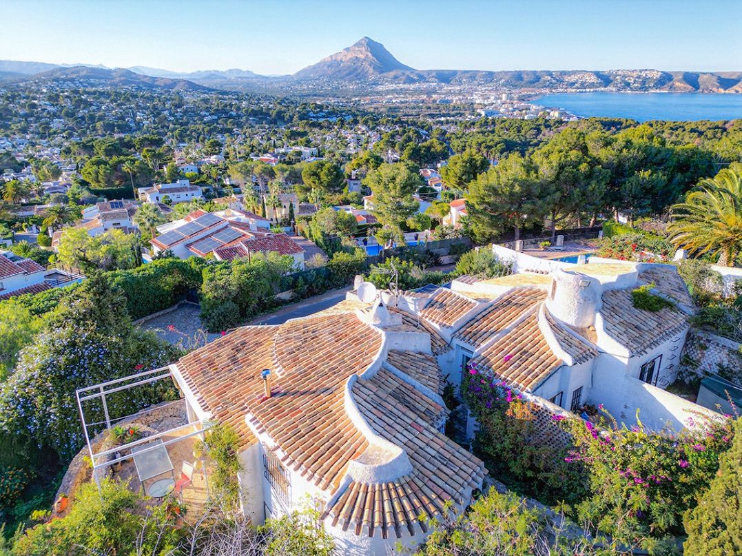 Luftaufnahme der traditionellen Villa mit geschwungenen Ziegeldächern und Panoramablick auf den Berg Montgó und die Bucht von Jávea.